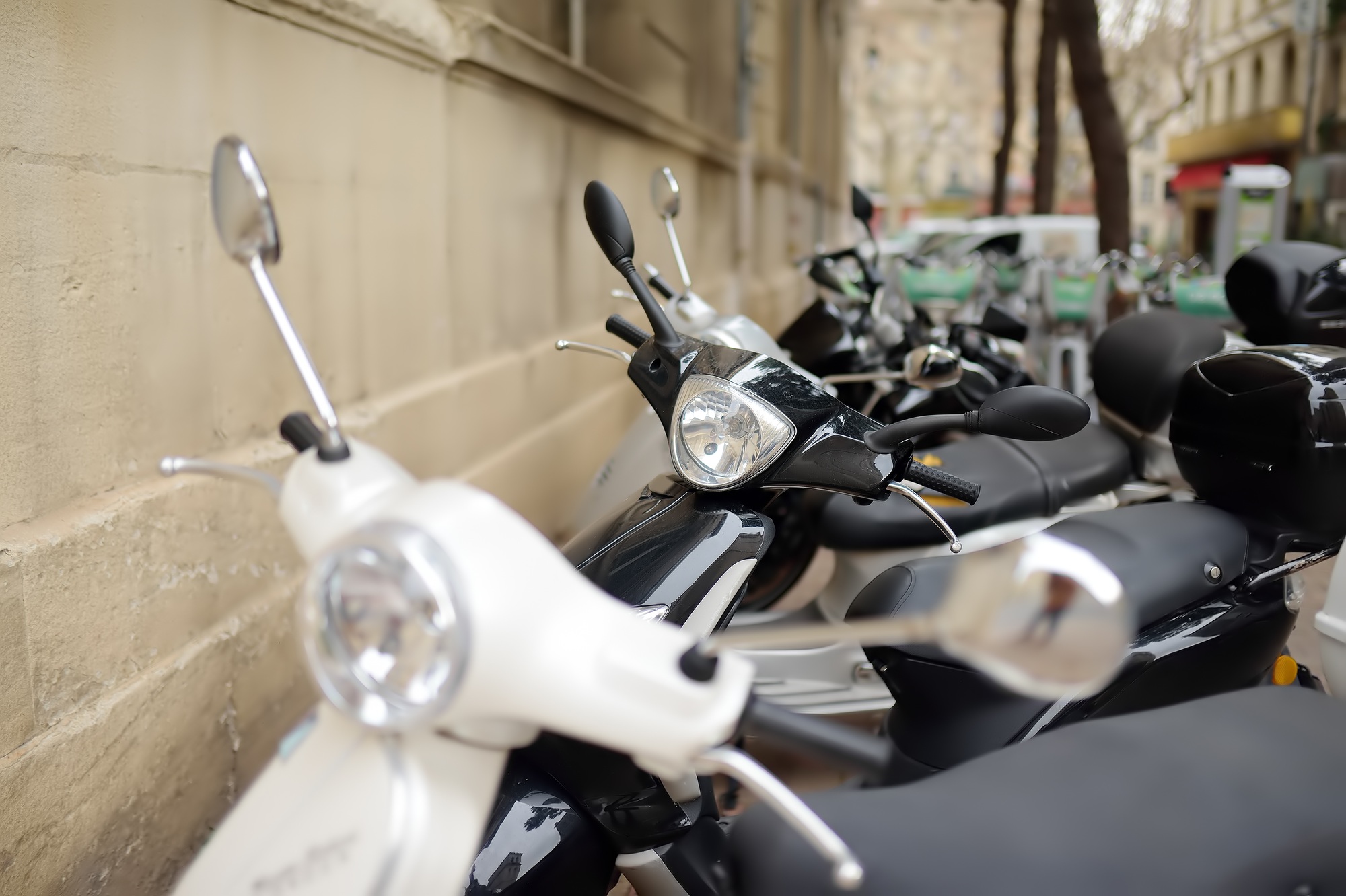 Motorcycle, scooters are parked on the narrow street.